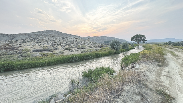 Head gate 1 on the Deaver canal delivers irrigation water Tuesday evening as the sun sets. The Deaver irrigation system benefited from the work of the Civilian Conservation Corps in 1935. Carla Wensky