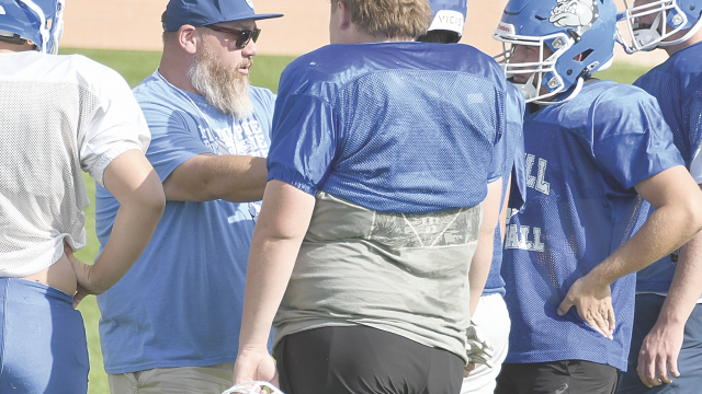 Line coach Logan Blau instructs Lovell High School linemen prior to a drill during practice Monday evening. The Bulldogs travel to Buffalo Saturday for a zero-week game. David Peck