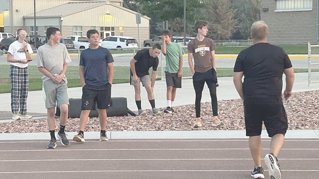 The Rocky Mountain cross country team, (l-r) Avery Thomas, Zach Unruh, Derek Hedges, James Demers, Tristan Kerchner and Rowan Hanusa, listen attentively to last-minute instructions from Coach Jerry Burton (far right) before beginning an intense track workout earlier this week. Courtesy Photo 